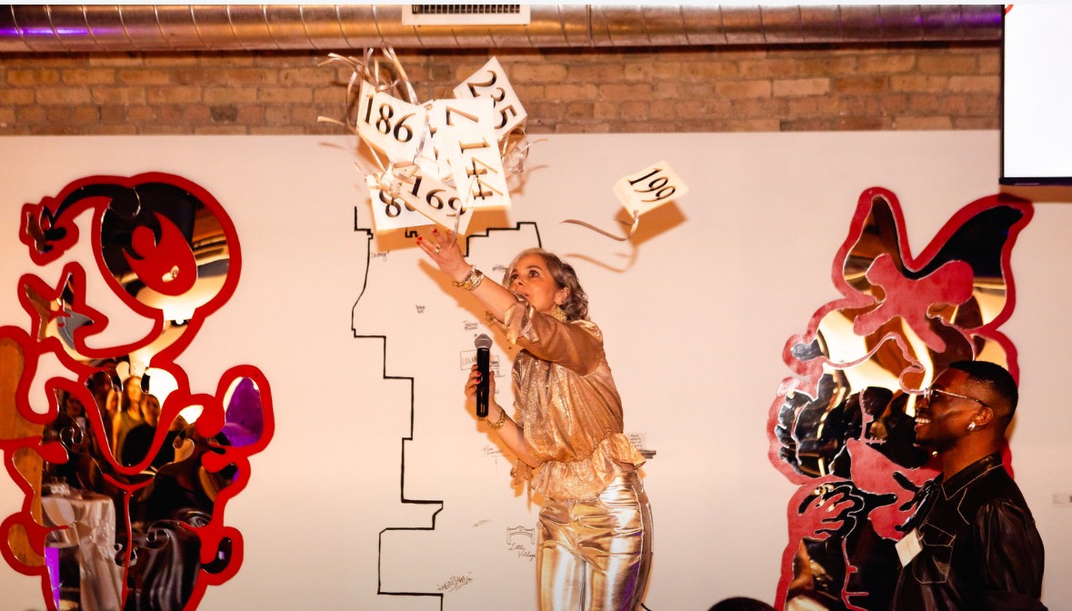 Molly Morse Limmer tossing bid paddles at a Marwen Foundation benefit auction